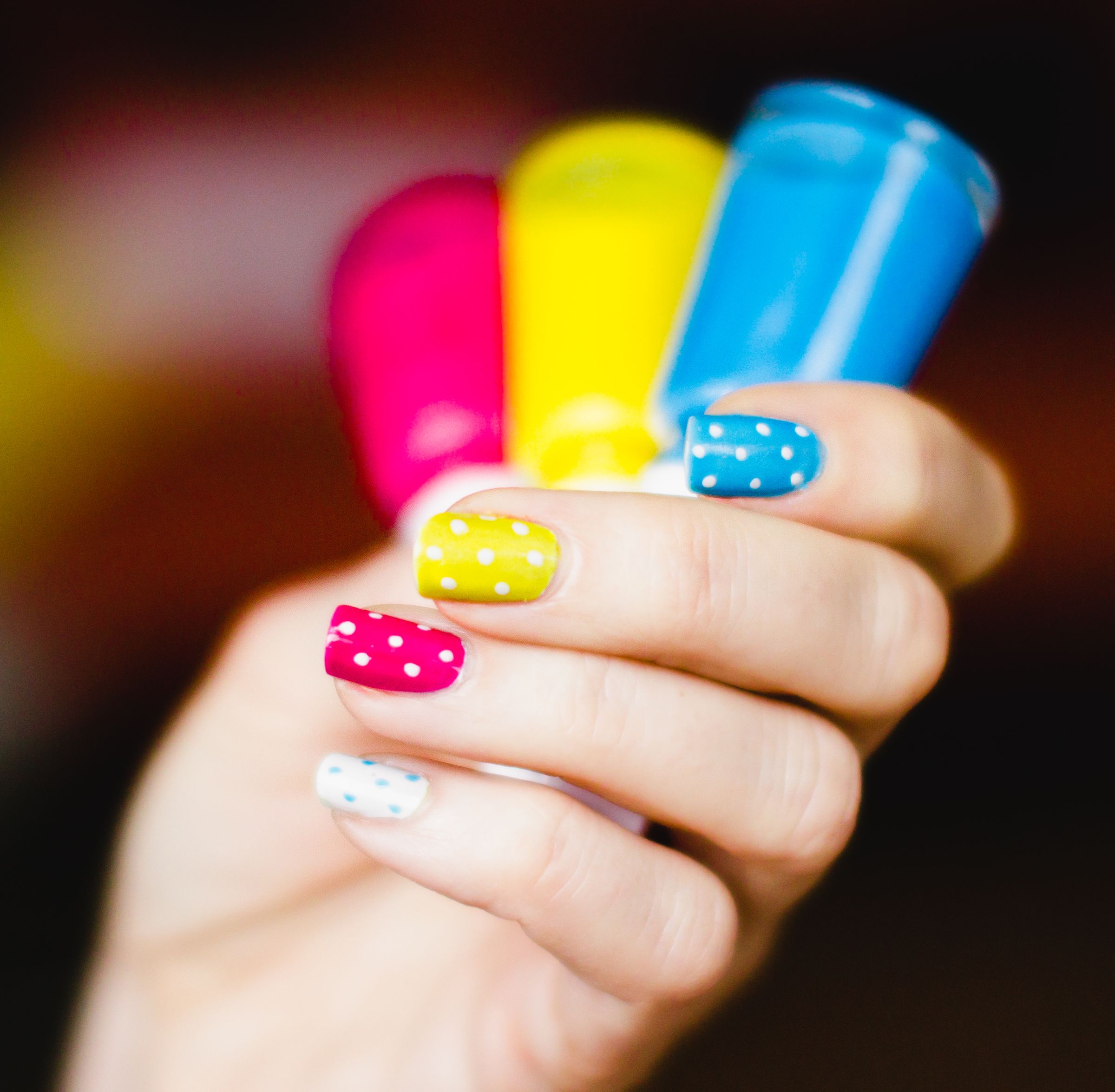 Pink, yellow, blue, and white polka-dot manicure